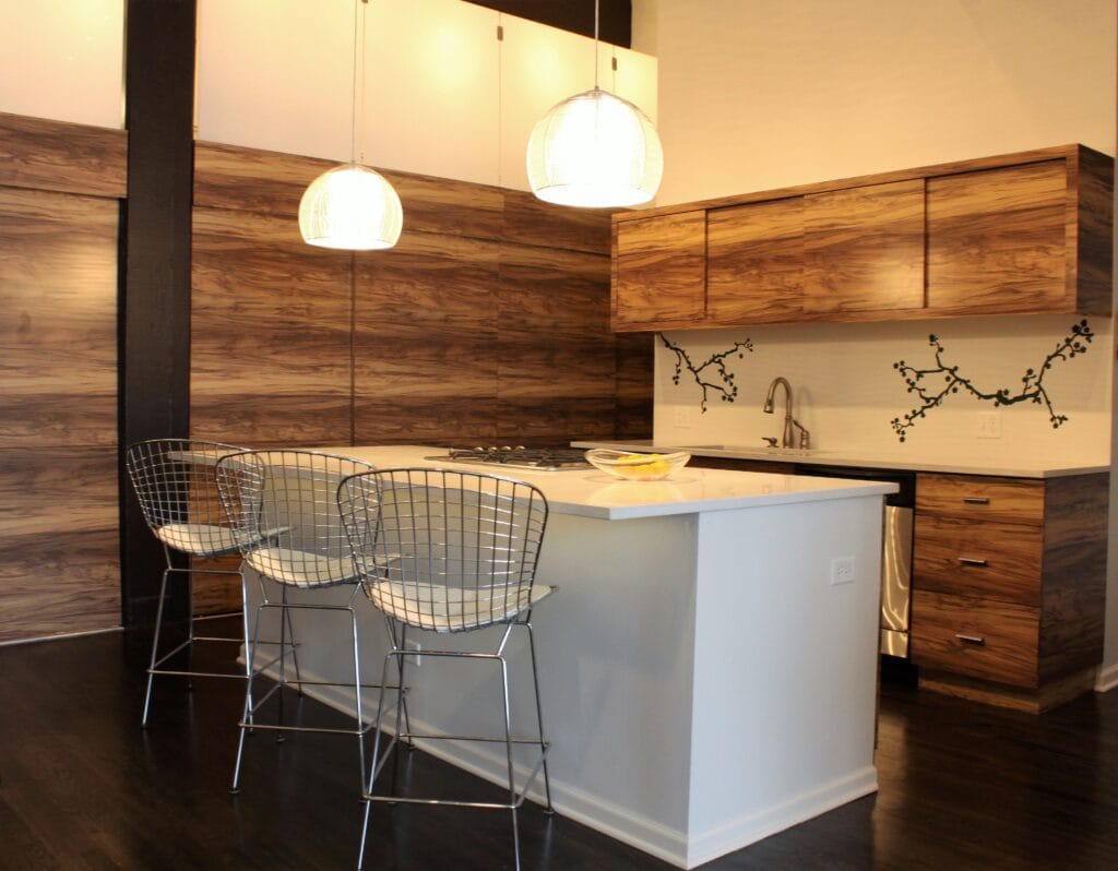 Modern loft kitchen interior with custom wood cabinetry, white waterfall island, and pendant lighting designed by Jordan Guide Design