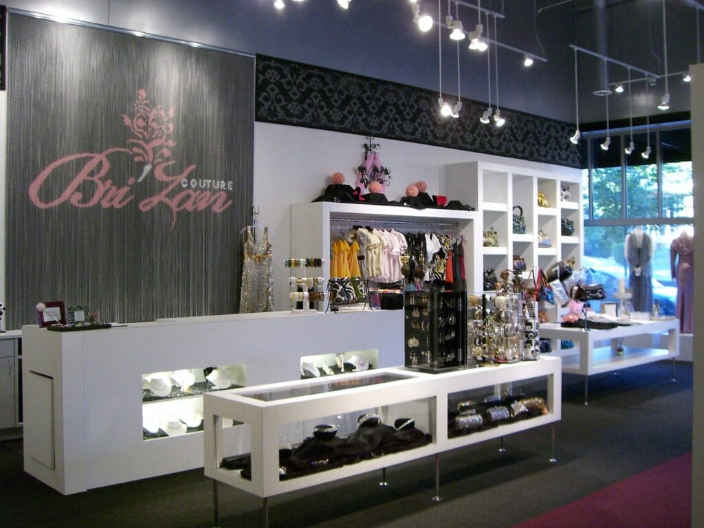 Naperville couture boutique interior designed by Jordan Guide Design featuring custom display tables, illuminated shelving, runway-style layout, and luxury retail finishes